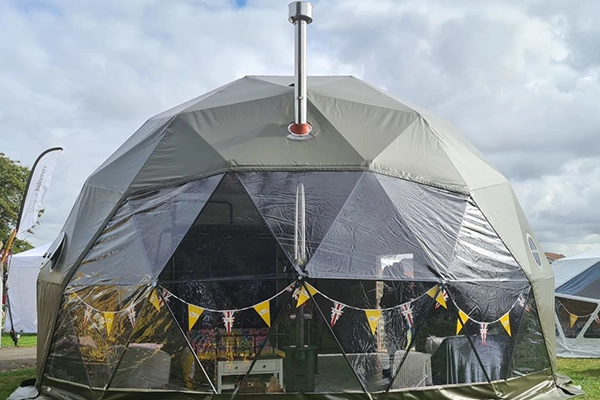 A grass campsite with a dome from TruDomes